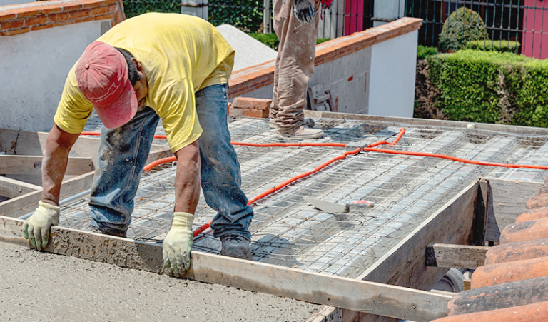 Trabajador utilizando materiales para techar la obra